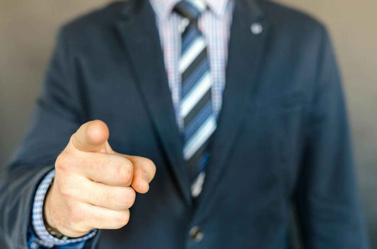 Corporate gift suppliers in Singapore; corporate gift ideas; man in suit and striped tie pointing at viewer